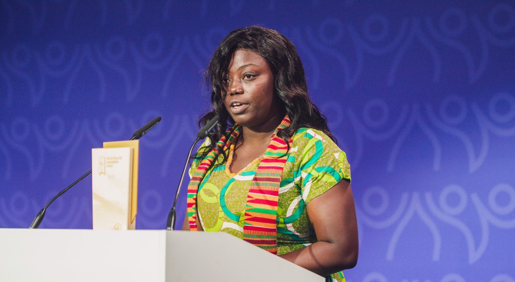 African woman speaking at a podium